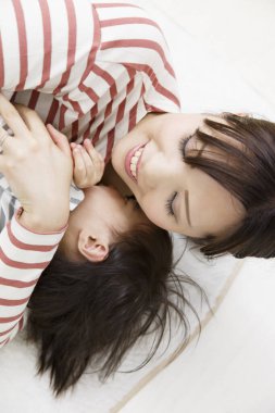 Mutlu Asyalı anne ve çocuk evde eğleniyor.