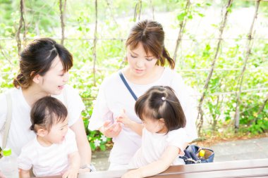 Parktaki küçük kızları olan Asyalı anneler.