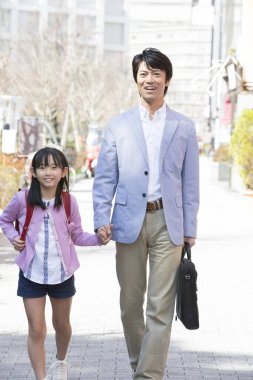 Japon adam ve liseli kız sokakta yürüyorlar. 