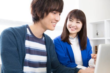 Evde dizüstü bilgisayar kullanan genç çift.