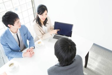 Genç Japon iş adamları ofiste dizüstü bilgisayarla çalışıyorlar.