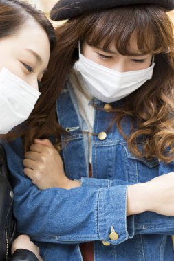 Dışarıda uyanan tıbbi maskeli Asyalı kadınlar. 