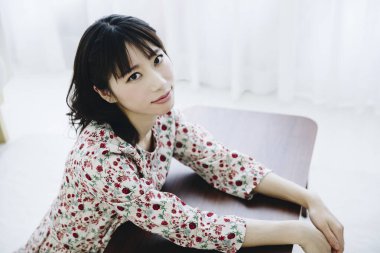 Evdeki masada oturan genç ve güzel bir kadın.