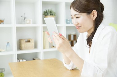 Evde tablet bilgisayarı olan genç bir kadın.