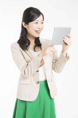 Beyaz arka planda tablet kullanan güzel Japon kadın 