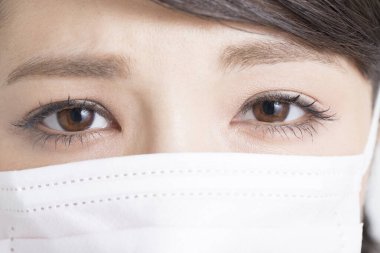 Yüz maskesi takan Asyalı kadın, yakın plan.