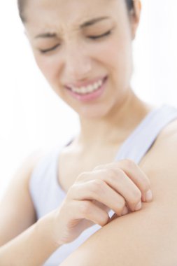 Beyaz arka planda kaşındıran derisi olan genç bir kadın. Sağlık ve Tıp Konsepti