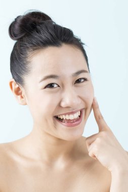 gülümseyen kadın tenine dokunuyor 