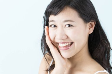 Genç Asyalı kadın gülümsüyor, stüdyo fotoğrafı. 