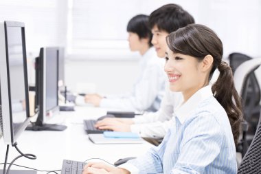 Ofisteki bilgisayarlarda çalışan genç iş adamları