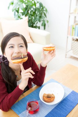 Evde çörek yiyen bir kadın. 