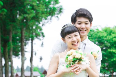 Parktaki genç Asyalı yeni evlilerin portresi.