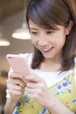 Kahve dükkanında cep telefonu kullanan kadın