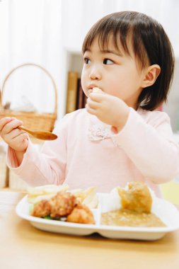 Güzel Asyalı kız evde Japon yemeği yiyor.