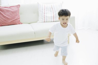 Odada koşan sevimli küçük çocuk.