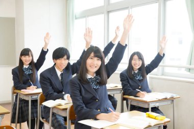 Genç Japon öğrenciler sınıfta okuyor.