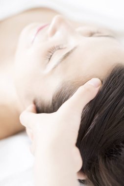 Genç ve güzel Japon kadın spa merkezinde yüz masajından zevk alıyor..