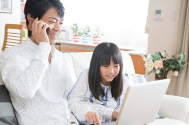 Mutlu Asyalı aile dizüstü bilgisayar kullanıyor.