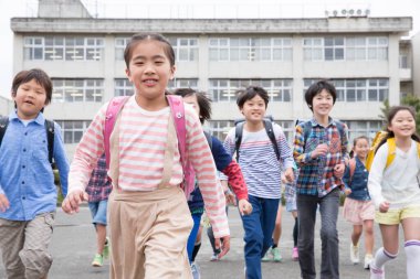 Okuldan sonra koşan bir grup mutlu Asyalı çocuk.  