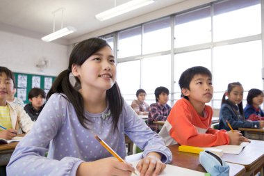 Japon ilkokul öğrencileri sınıfta yazıyor. eğitim kavramı
