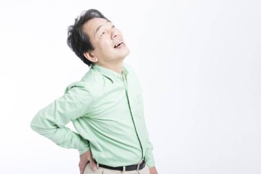  Beyaz arka planda sırt ağrısı çeken yaşlı bir Asyalı..