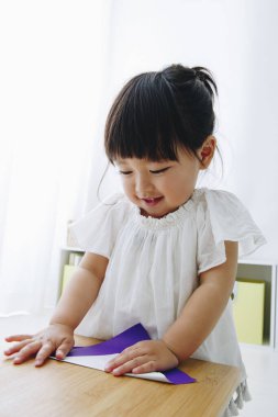 Oturma odasında oynayan küçük tatlı bir Japon kız.