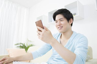 evde akıllı telefon kullanan adam