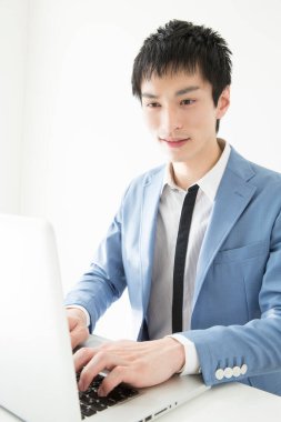 Ofisinde dizüstü bilgisayarda çalışan genç bir adamın portresi.