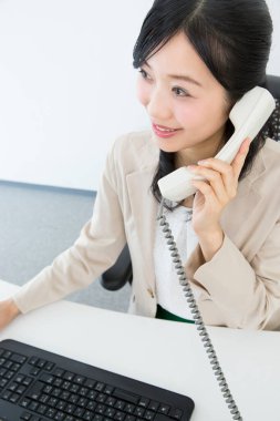 Genç Asyalı kadın işçi bilgisayar kullanıyor.