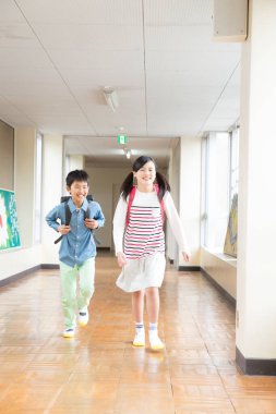 Okul koridorunda koşan iki mutlu okul çocuğunun portresi. 
