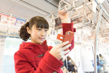 Trende akıllı telefon kullanan bir kadın.