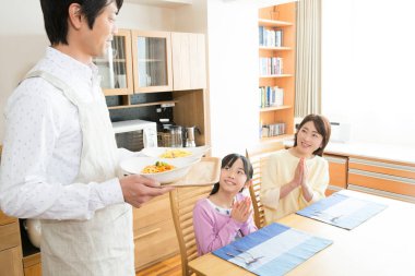 Genç baba sabahki yemek için hazırlanıyor.