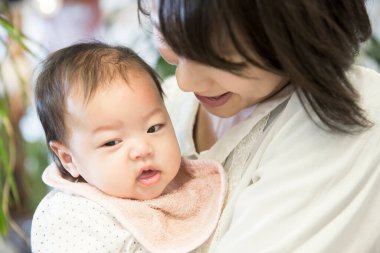 Küçük kızıyla birlikte genç Asyalı anne. 