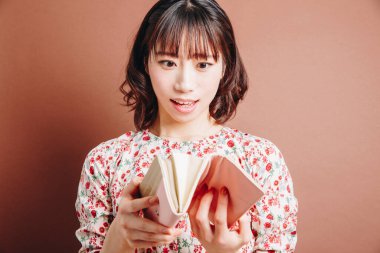 Boş cüzdan taşıyan genç bir kadın.