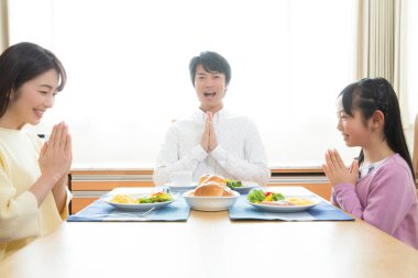 Kahvaltıdan önce masada üç kişilik mutlu bir aile. 