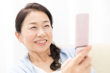 Evde bir cep telefonu kullanan kadın 