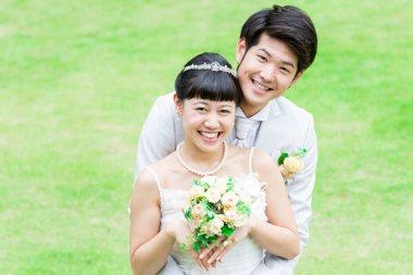 Parktaki genç Asyalı yeni evlilerin portresi.