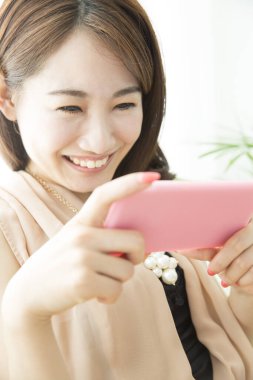 Akıllı telefon kullanan güzel Asyalı kadın, portreyi kapat.