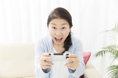Video oyunu oynayan Asyalı kadın