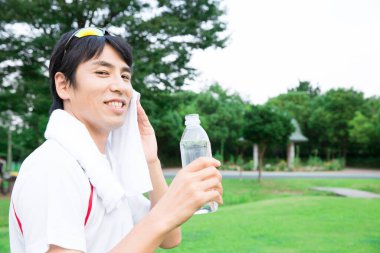 Yürüyüşten sonra su içen genç bir adamın portresi