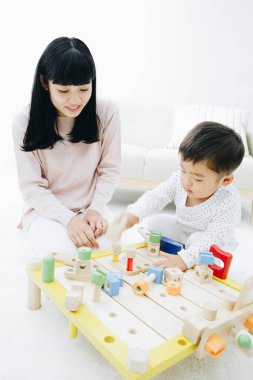 Evde annesiyle oynayan tatlı Japon çocuk.