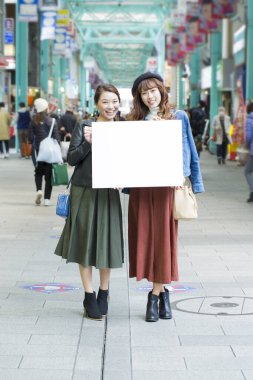 Şehirde boş kartı olan Asyalı kadınlar. 