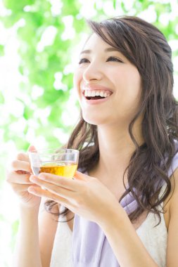 Bahçede çay içen genç bir kadın