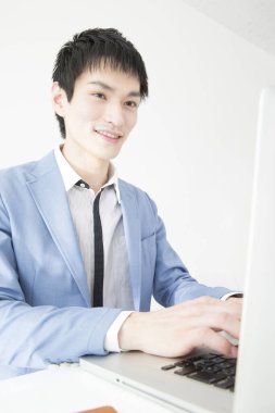 Ofisinde dizüstü bilgisayarda çalışan genç bir adamın portresi.