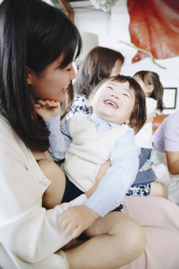 Gülen çocuğu kucağında tutan kadın.