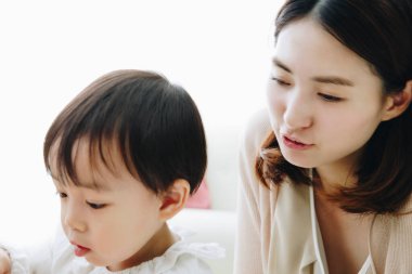 Asyalı anne ve küçük oğlu evde, yaşam tarzında ve aile kavramında oynuyorlar..