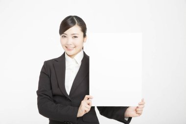 Genç Asyalı kadın beyaz arka planda izole edilmiş boş bir karta uluyor. 