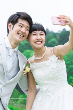 Asyalı gelin ve damat selfie çekiyor. 