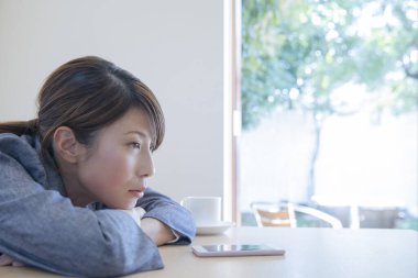 Bir fincan kahve ve akıllı telefonlu bir kadın. 