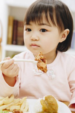 Güzel Asyalı kız evde Japon yemeği yiyor.